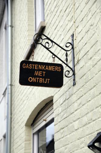 a sign hanging on the side of a brick building at Gastenkamers Boussemaere in Ichtegem
