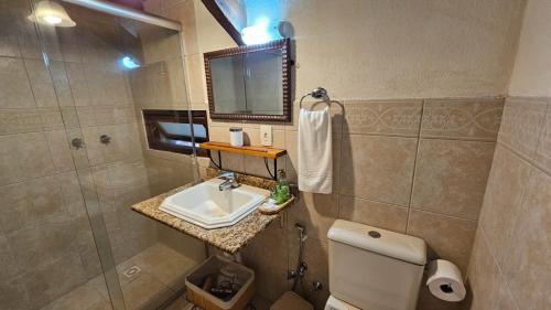 a bathroom with a sink and a toilet and a shower at Pousada Borghetto – Charme e Exclusividade no Vale dos Vinhedos in Bento Gonçalves