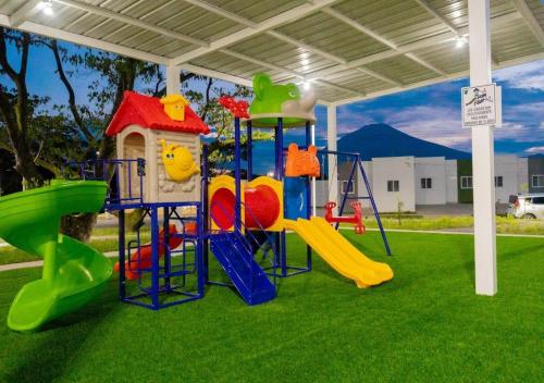 un parque infantil con un tobogán en el césped en VillaOriental, en San Miguel