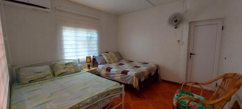 a small room with two beds and a window at Tamarin Beach House in Tamarin