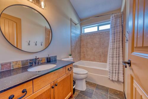 a bathroom with a sink and a toilet and a mirror at Exceptional Boutique Cottage with Incredible Lake View in Kelowna