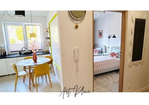 a kitchen and a dining room with a table and a bedroom at Art Place in Tomaszów Mazowiecki