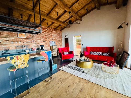 Il comprend un salon doté d'un mobilier rouge et d'un mur en briques. dans l'établissement Terradigaya, à Pietrosella