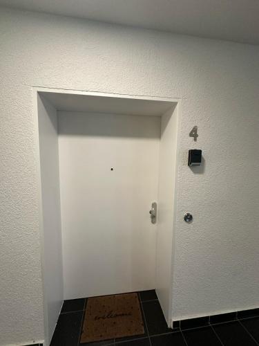 a white door in a room with a wall at Al Nafurah Apartments in Munich