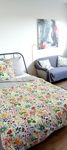- une chambre avec un lit et une couverture fleurie dans l'établissement Appartement Zen Strasbourg center avec parking, à Strasbourg