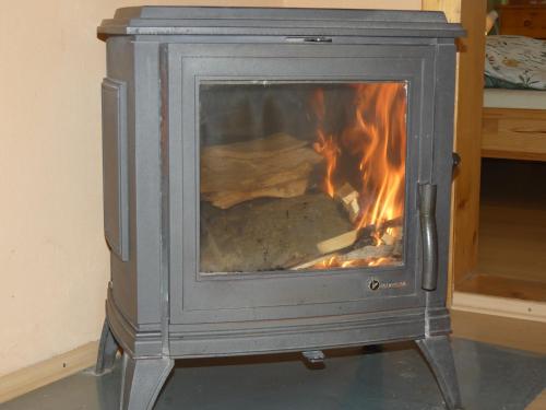 a stove with a fire in a room at Forester Apartment Zuberec in Zuberec