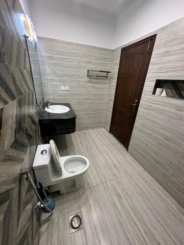 a bathroom with a toilet and a sink at Travis Executive Guest House Islamabad in Islamabad