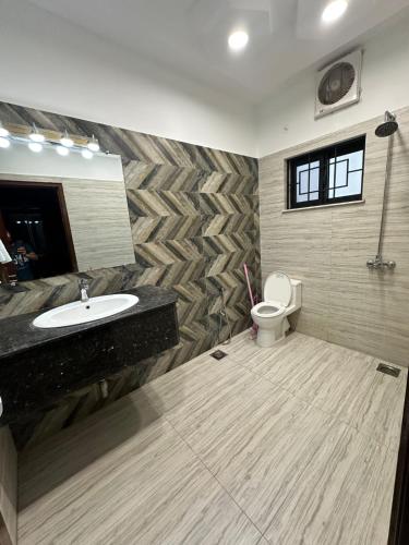 a bathroom with a sink and a toilet at Travis Executive Guest House Islamabad in Islamabad