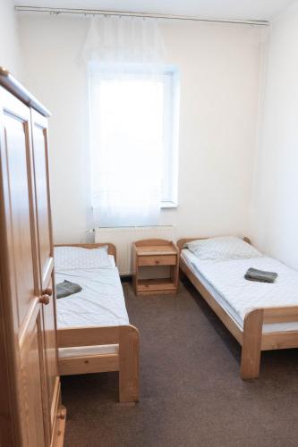 two beds in a room with a window at Ubytovna Bayer in Otrokovice