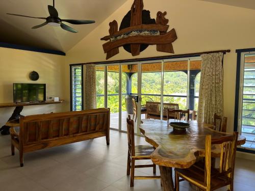a dining room with a wooden table and chairs at Potter House TSUKAMOTO Vue sur Baie de Maroe in HUH