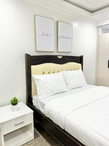 a bedroom with a large bed with two pictures on the wall at Calm Haven - Cozy Home in Ruiru