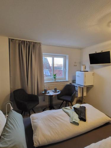 a hotel room with a bed and a table and chairs at Ankerplatz in Travemünde