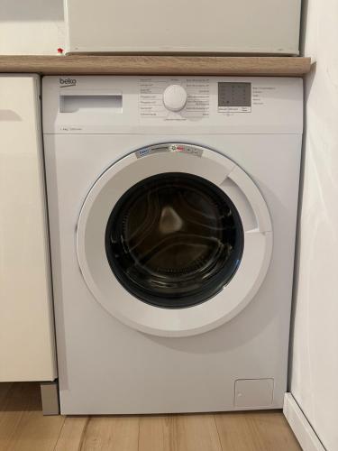a white washing machine with a microwave on top of it at Cheap Outlet Center Apartment with Pool in Parndorf