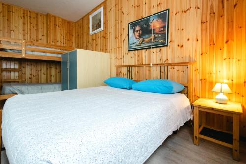 a bedroom with a white bed and wooden walls at Casa vacanza Miralago in Antronapiana