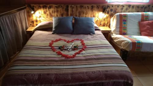 a bed with a red heart on top of it at La Traviesa in Soneja
