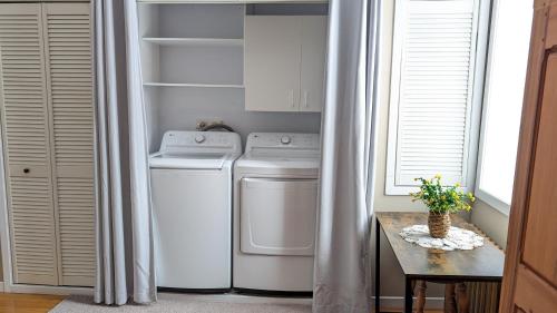 a laundry room with a washer and dryer and a table at La Gentilhommière in Saint-Siméon