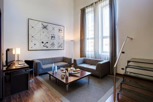 a living room with a couch and a table at Hotel Sercotel Ciutat D'Alcoi in Alcoy
