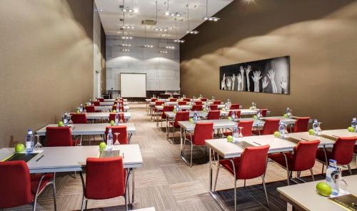 a dining room with tables and chairs and a whiteboard at Hotel Sercotel Ciutat D'Alcoi in Alcoy