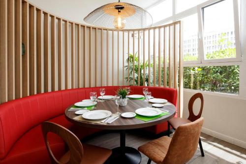 a dining room with a table and red chairs at Sercotel AB Rivas in Rivas-Vaciamadrid