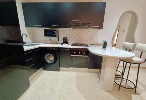 a kitchen with a table and a washing machine at Cosy appartement au cœur de Gueliz in Marrakech