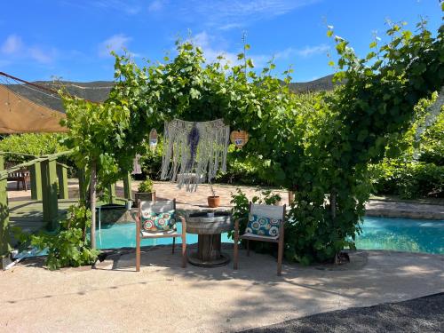 a pergola with a table and chairs next to a pool at Lago Amor de Valle Glamping in Villa de Juárez