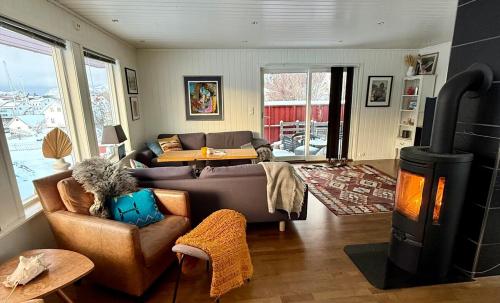ein Wohnzimmer mit einem Sofa und einem Holzofen in der Unterkunft Perfect house in Henningsvær with sea-view in Henningsvær
