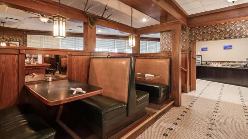 a restaurant with leather chairs and a table and a bar at Best Western Ramkota Hotel Aberdeen in Aberdeen