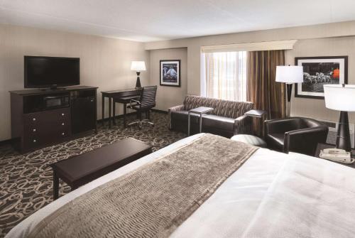 a hotel room with a bed and a television at Best Western Ramkota Hotel Aberdeen in Aberdeen