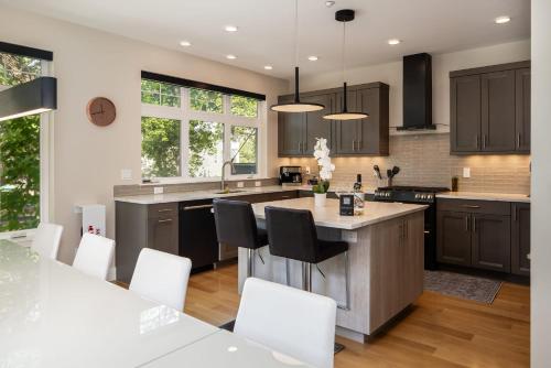 a kitchen with a large island with white chairs at Your Downtown Urban Sanctuary - Walk to EVERYTHING in Bozeman