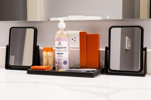 a bathroom counter with two mirrors and a bottle of soap at Your Downtown Urban Sanctuary - Walk to EVERYTHING in Bozeman