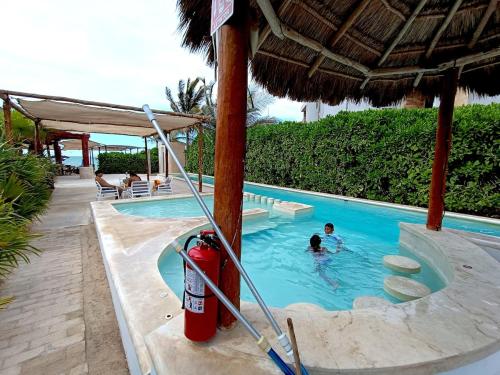 two people in a swimming pool at a resort at Casa Apolo, piscina y club de playa in Chelem