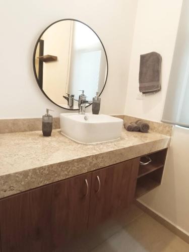 a bathroom with a sink and a mirror at Casa Apolo, piscina y club de playa in Chelem