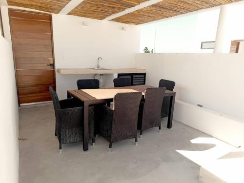 a dining room with a wooden table and chairs at Casa Apolo, piscina y club de playa in Chelem