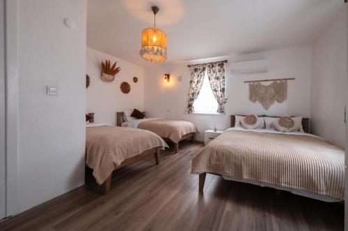 a room with three beds and a chandelier at Heros Hotels Bozcaada in Bozcaada