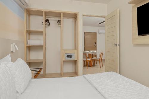 a bedroom with a white bed and a dining room at Radisson Riviera Panama in Punta Chame