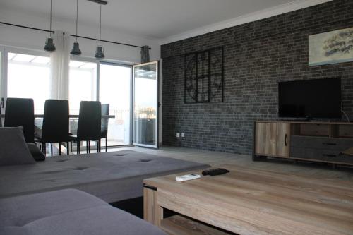 a living room with a couch and a television at Dreamsun in Portimão