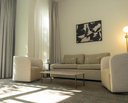 a living room with a couch and chairs and a table at Hôtel Saint-Sulpice in Montréal