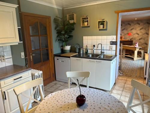 a kitchen with a table and a sink and a table and chairs at Gîte de la Ruelle in Couvin