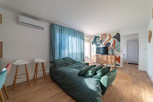 un salon avec un lit et une table dans l'établissement Fables du Jardin de la Fontaine, à Nîmes