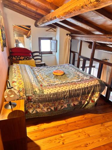 a bedroom with a bed with a quilt on it at Rifugio di Nonno Gabriele in Santo Stefano di Sessanio