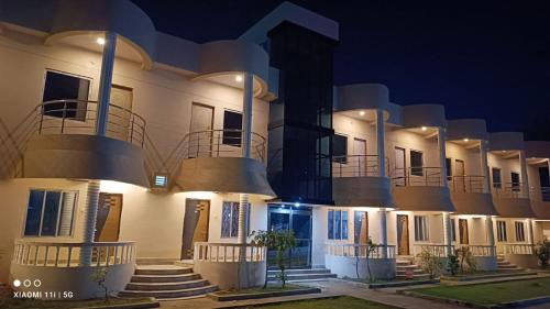 a large white building with balconies at night at Sea Land Mandarmani in Mandarmoni