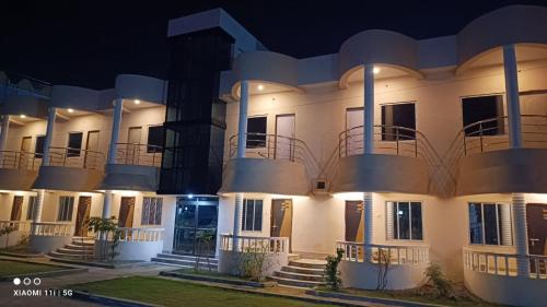 a large white building with balconies at night at Sea Land Mandarmani in Mandarmoni