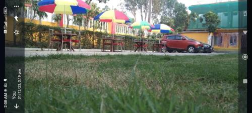 a red car parked next to tables with umbrellas at Sea Land Mandarmani in Mandarmoni