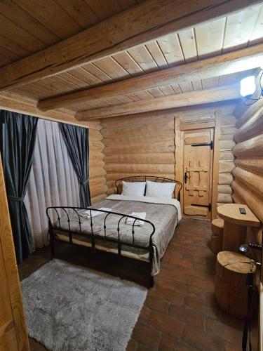 a bedroom with a bed in a wooden room at Cabana Daria Arieseni in Arieşeni