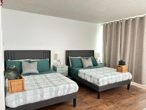 two beds sitting next to each other in a bedroom at Hollywood Blvd Studio FREE DESIGNATED PARKING & WIFI in Los Angeles