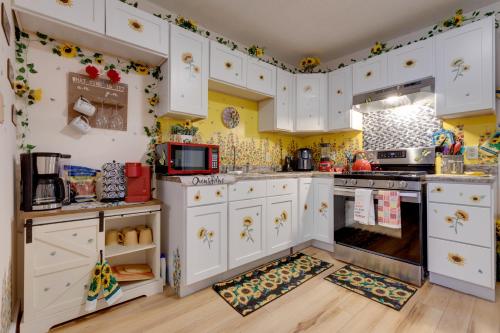 a kitchen with white cabinets and yellow walls at Stunning Gulfport Getaway about 1 Mi to the Beach in Gulfport