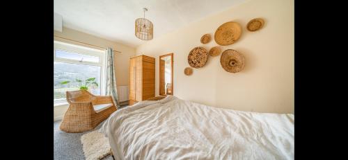 ein Schlafzimmer mit einem Bett und einem Fenster in der Unterkunft Quirky Mountain Cottage in Pontardawe