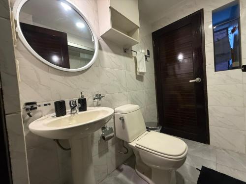 a bathroom with a toilet and a sink and a mirror at 1D apartment in the best area of La Paz in La Paz