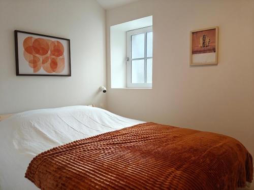 a bedroom with a bed and a window at Grand appart 2 chambres - Hyper centre - Calme in Chinon