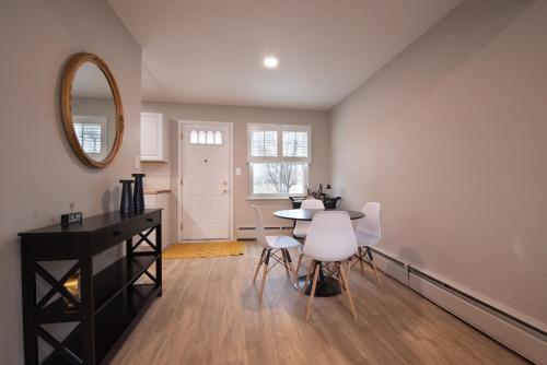 a dining room with a table and white chairs at Cozy Condo in the Heart of Royal Oak in Royal Oak